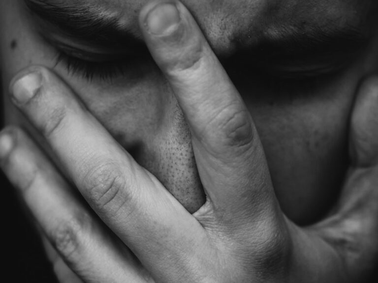 Person in a toxic relationship hiding their face in despair
